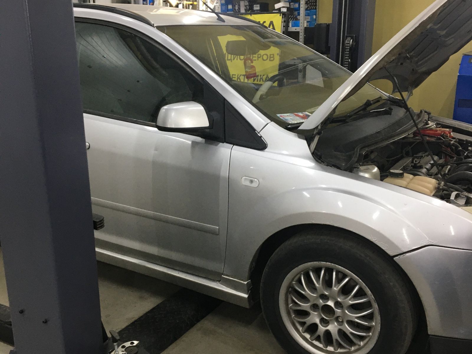 Автомобиль на подъёмнике с открытым капотом